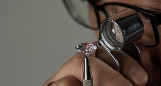 Man examining a diamond through magnifier