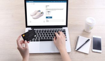 Woman entering bank card details to purchase shoes online