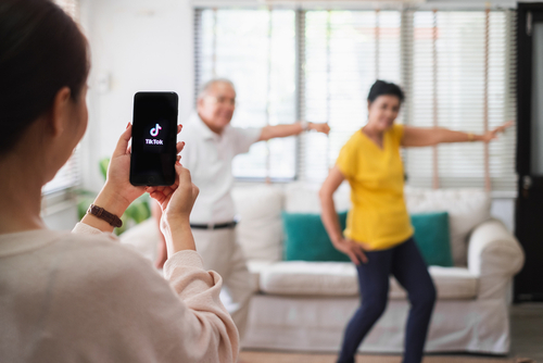 Woman recording two family members dancing for a TikTok
