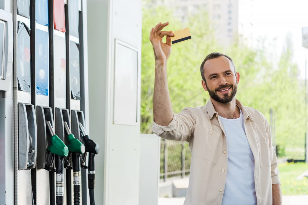 man smiling and holding fuel card a petrol pumps
