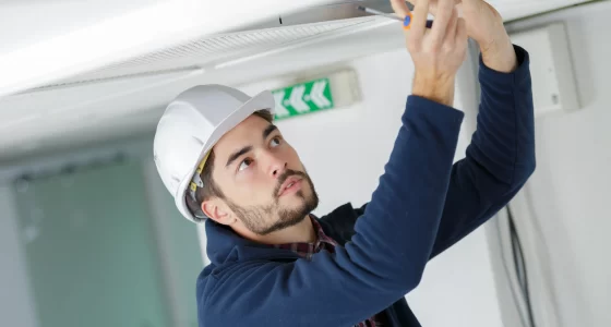 Man fitting a FlipFix access panel in the ceiling